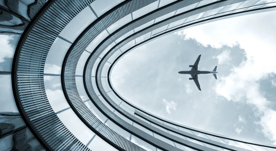 Modern building with landing airplane